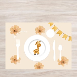 Könnte beinhalten: Ein beiger Platzteller mit einem weißen Teller, auf dem eine Comic-Giraffe abgebildet ist, sowie einer Gabel, einem Messer und einem Löffel. Der Platzteller ist mit gelben Flaggen, orangefarbenen Blumen und dem Text "Guten Appetit!" verziert.
