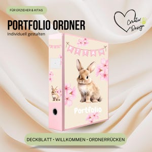 May include: A light beige binder featuring a brown bunny illustration, pink cherry blossoms, and a banner with the text KITA. The word Portfolio is printed in white at the bottom. The spine includes a small bunny graphic and a metal ring hole.
