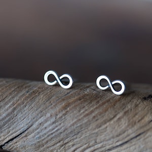 Op de afbeelding: Een paar zilveren oorringen met een oneindigheidssymbool. De oorringen zijn klein en delicaat en perfect voor dagelijks gebruik.