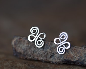May include: A pair of silver earrings with a Celtic knot design. The earrings are small and delicate, and they are perfect for everyday wear.
