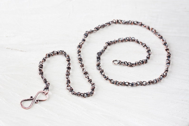 May include: A copper chain necklace with a twisted wire design. The chain is approximately 20 inches long and has a lobster clasp closure.