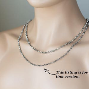 May include: Two silver chains layered on a model's neck. The text "This listing is for a smaller link version." is visible below the chains.
