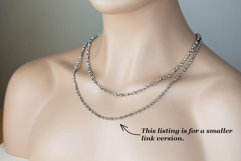 May include: Two silver chains layered on a model's neck. The text "This listing is for a smaller link version." is visible below the chains.