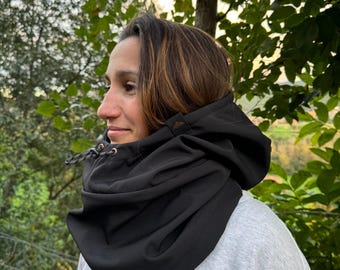 May include: A black hooded neck gaiter with a drawstring closure. The gaiter is made of a soft, stretchy fabric and is designed to keep the wearer warm and comfortable.