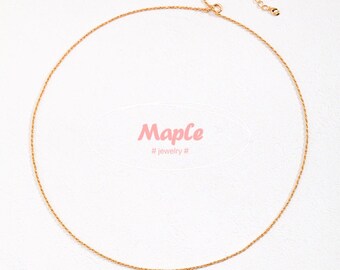 May include: A delicate gold chain necklace with a lobster clasp closure. The chain is a simple, thin, rope style. #jewelry#