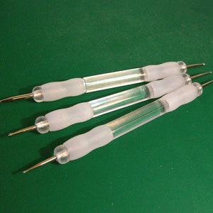 Puede incluir: Tres herramientas de acrílico transparente con puntas metálicas para nail art. Las herramientas tienen una punta redonda, una punta puntiaguda y una punta con una pequeña bola en el extremo.