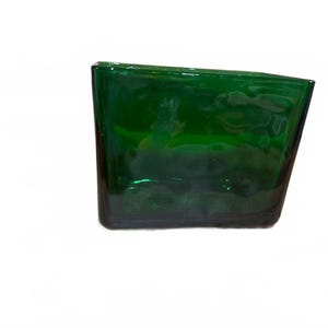 May include: A rectangular emerald green glass vase with a slightly slanted top edge. The glass features a wavy, textured surface that creates light reflections and depth throughout the body of the vessel, giving it a distinct appearance.