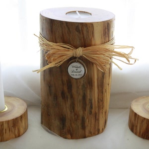 May include: Two wooden candle holders with a single white candle in each. The center holder is decorated with a brown and beige ribbon and a tag that reads "Wendy & David July 14, 2013".