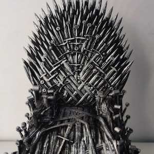 Könnte beinhalten: Ein detaillierter, metallischer Thron aus Schwertern. Die Rückenlehne des Throns besteht aus zahlreichen Schwertklingen, mit zusätzlichen Schwertern, die den Sitz und die Armlehnen bilden. Der Text "soulDesign" befindet sich in der oberen rechten Ecke.