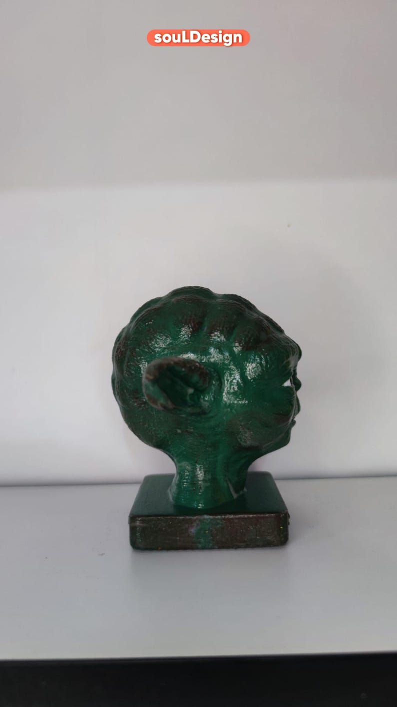 May include: A green Yoda head figurine on a brown base. The figurine is made of plastic and has a detailed face.