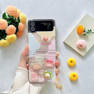 Funda con pulsera de dibujos animados en 3D para Samsung Galaxy Z Flip 3, 4, 5 y 6: carcasa trasera transparente a prueba de golpes con un diseño bonito y elegante.
