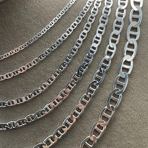 May include: A set of silver mariner chain necklaces of varying widths. The chains are displayed on a white background.