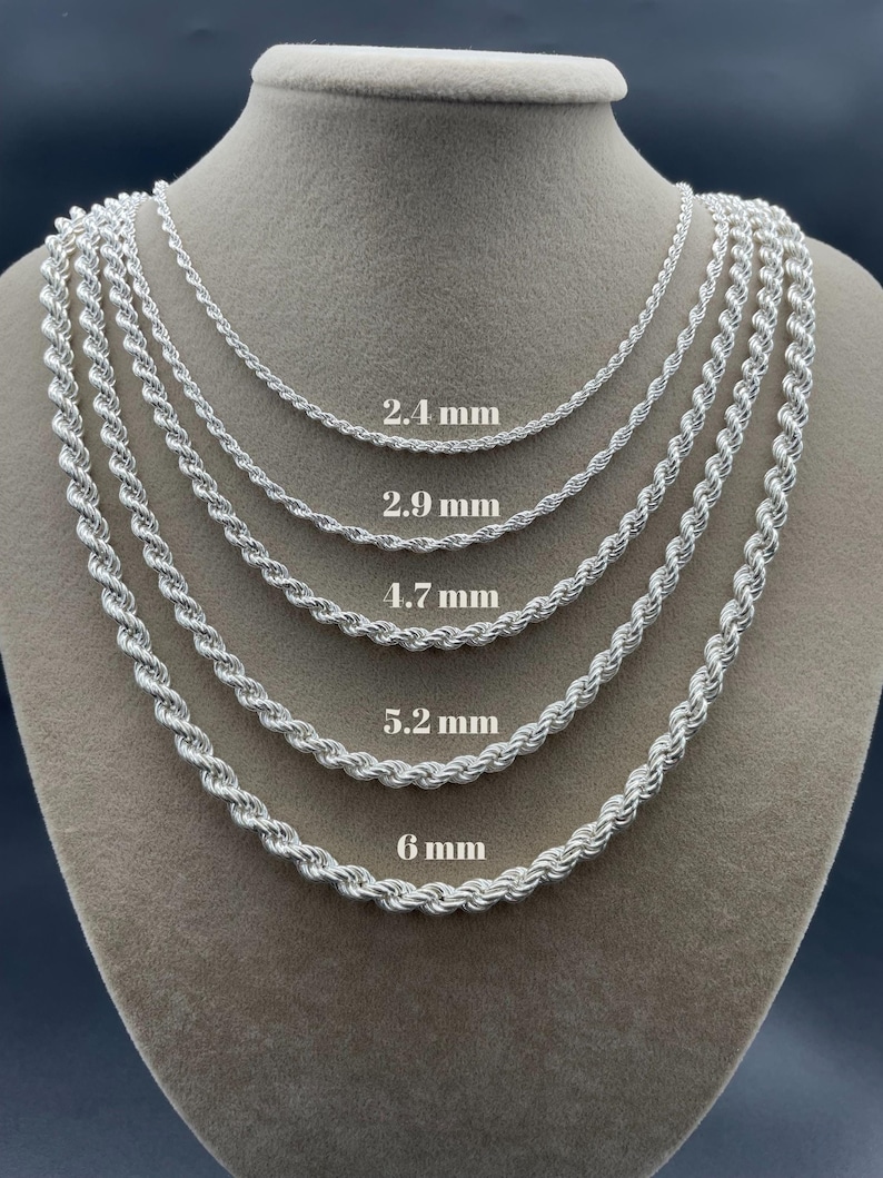May include: Five silver rope chains of different thicknesses displayed on a mannequin. The chains are labeled with their thickness in millimeters: 2.4 mm, 2.9 mm, 4.7 mm, 5.2 mm, and 6 mm.