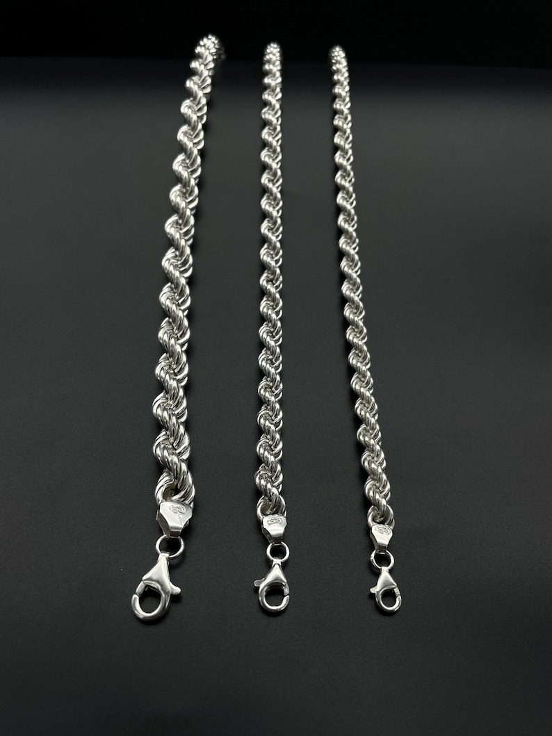 May include: Three silver rope chains of varying lengths. The chains are made of a twisted rope design and have a lobster claw clasp.