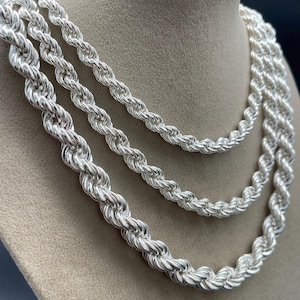 May include: Three silver rope chains of varying thicknesses, displayed on a mannequin's neck.