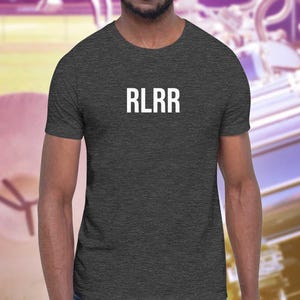 Può includere: Una t-shirt grigio scuro melange con il testo "RLRR" stampato in bianco sul davanti.