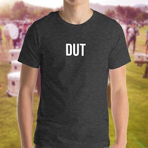 May include: A dark grey t-shirt with the word "DUT" printed in white on the front.