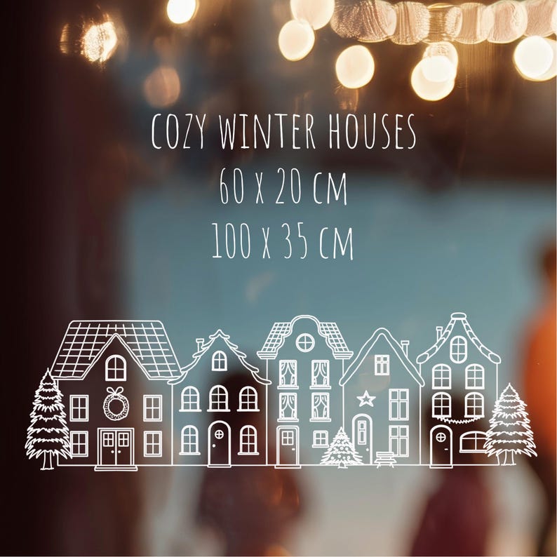 May include: A white line art decal featuring a row of five winter houses and two pine trees. The text reads COZY WINTER HOUSES, 60 x 20 CM, and 100 x 35 CM. The design includes details like wreaths, stars, and windows on the house facades.