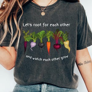 Może przedstawiać: Szary t-shirt z białym nadrukiem warzyw i tekstem "Let's root for each other and watch each other grow".