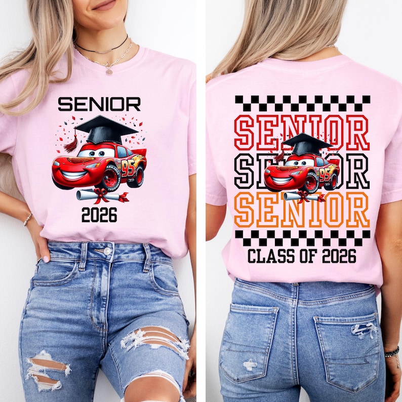 Puede incluir: Camiseta rosa claro con un gr&aacute;fico de un coche de carreras rojo con birrete, la palabra "SENIOR" y el a&ntilde;o "2026". La parte trasera de la camiseta repite la palabra "SENIOR" y "CLASS OF 2026".