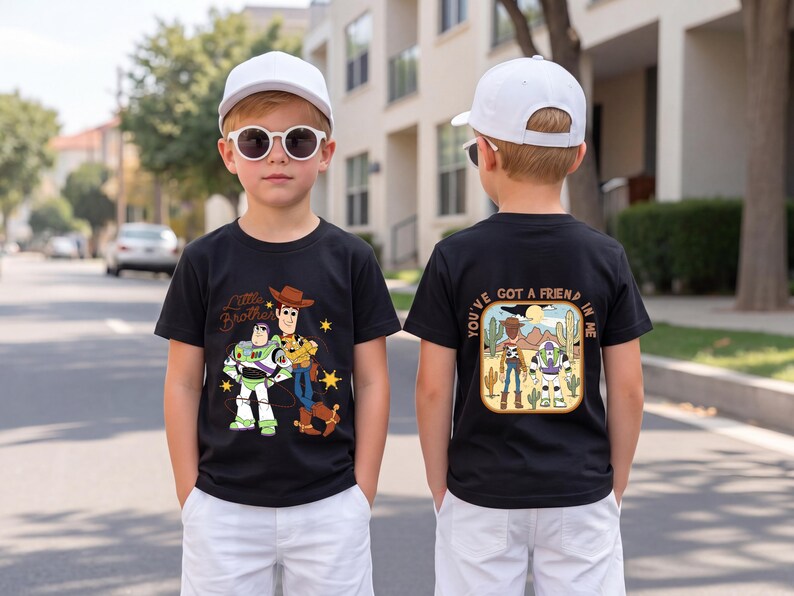 May include: A black t-shirt featuring a front graphic of Woody and Buzz Lightyear with the text Little Brother and a back graphic of the characters in a desert scene with the text You've Got A Friend In Me, paired with white shorts and a white cap.