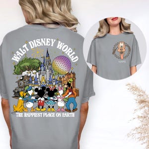 May include: Gray t-shirt featuring a colorful graphic of Disney characters and the text "Walt Disney World" and "The Happiest Place on Earth." The front of the shirt has a Pluto graphic with a checkered border and the word "Name".
