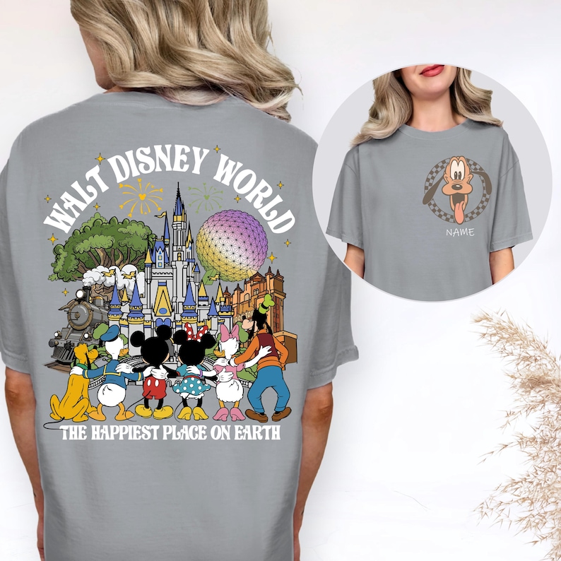 May include: Gray t-shirt featuring a colorful graphic of Disney characters and the text "Walt Disney World" and "The Happiest Place on Earth." The front of the shirt has a Pluto graphic with a checkered border and the word "Name".