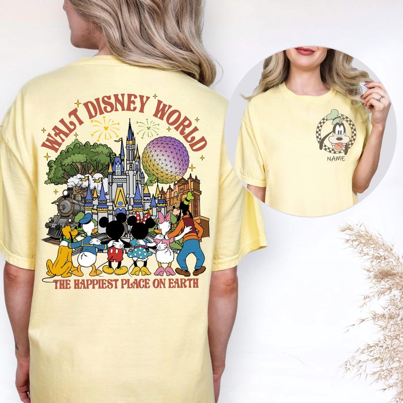 May include: A light yellow t-shirt featuring a colorful graphic of Disney characters and landmarks. The back of the shirt displays the words "WALT DISNEY WORLD" and "THE HAPPIEST PLACE ON EARTH". A smaller image of Goofy is on the front.