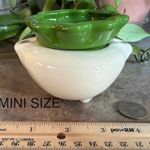 May include: A small, off-white ceramic bowl with a green, scalloped-edge bowl nested inside. The text "MINI SIZE" is below the bowls. A ruler shows the bowls are approximately 3 inches wide.