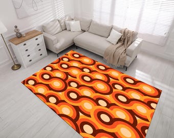 May include: A retro-style area rug with a repeating pattern of orange, brown, and cream colored circles. The rug is laid out on a light wood floor in a living room setting.