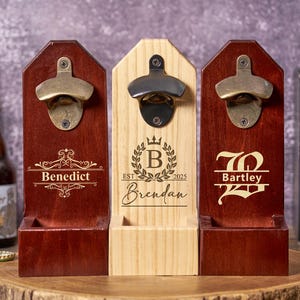 May include: Three wooden bottle openers with personalized engravings. Two are dark red, and one is natural wood. Each has a metal bottle opener attached. The engravings include names and decorative elements.