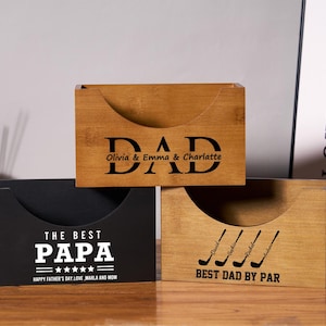 May include: Three wooden desk organizers with curved front openings. One is black with "THE BEST PAPA" and "HAPPY FATHER'S DAY" text. Another is light brown with "DAD" and names. The third is light brown with golf clubs and "BEST DAD BY PAR".