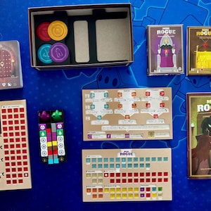 Op de afbeelding: Een bordspelset met diverse componenten, waaronder speelkaarten, fiches en regelboeken. Het spel bevat een doos met compartimenten, kleurrijke fiches en kaarten met illustraties. Het spel heet "Mini Rogue".