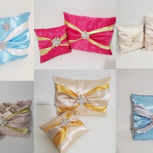May include: Assortment of decorative throw pillows with satin fabric and jeweled embellishments. The pillows are in various colors, including blue, pink, gold, and beige.