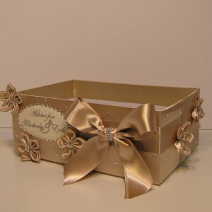 May include: A gold box with a satin ribbon and bow. The box has a label that says "Advice for Kimberly & Erik".