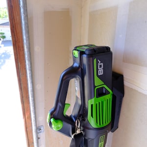 Soporte de pared resistente Greenworks para soplador de hojas de 80 V (modelo BLB489) / Soporte de 2 tornillos / Gancho organizador para garaje / Soporte seguro para herramientas de jardín