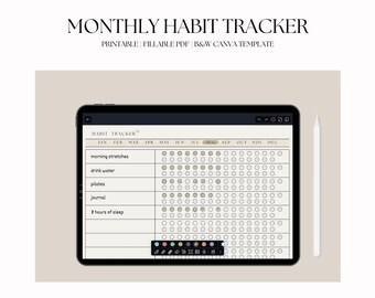 May include: A digital habit tracker displayed on a tablet, with a white stylus resting beside it. The tracker is designed to monitor daily habits, with sections for morning stretches, water intake, Pilates, journaling, and sleep. The text "MONTHLY HABIT TRACKER" is at the top.