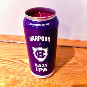 May include: Purple candle in a can with the Harpoon Brewery logo and the text "Hazy IPA" and "Holy Cross".