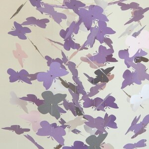 May include: A purple, pink, and gray butterfly mobile with multiple butterflies hanging from a central point.