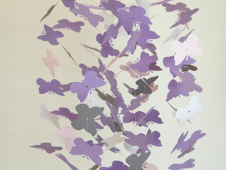May include: A purple, pink, and gray butterfly mobile with multiple butterflies hanging from a central point.