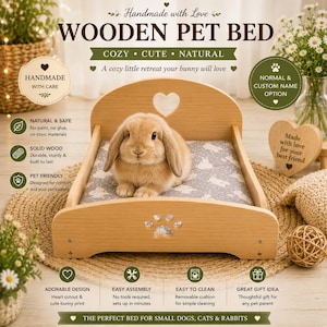 May include: A light-coloured wooden pet bed featuring a heart-shaped cutout in the headboard and a paw print cutout in the footboard. A light brown rabbit sits on a grey cushion patterned with white rabbits inside the wooden frame.