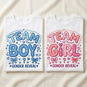 Peut inclure: Deux t-shirts blancs pliés avec des motifs de révélation du sexe. L'un affiche "TEAM BOY" en bleu, l'autre "TEAM GIRL" en rose. Les deux ont des éléments décoratifs tels que des nœuds, des cœurs et des points d'interrogation.