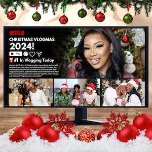May include: A computer monitor shows a Netflix Christmas Vlogmas 2024! graphic with a woman's face. The screen displays a collage of images with people in festive attire. Red and green Christmas baubles hang above the monitor.