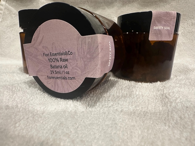 Puede incluir: Tres frascos de vidrio marr&oacute;n con tapas negras. Cada frasco tiene una etiqueta de color lila claro con el texto "Fiori Essentials&Co 100% Raw Batana oil 29,5 ml / 1 oz fioriessentials.com". Las etiquetas tambi&eacute;n dicen "SAFETY SEAL".