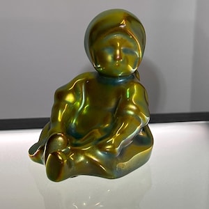 Zsolnay Hungary Vintage Eosin Figurine | 3” Seated Child in Bonnet, Iridescent Green Gold Ceramic | Mid-Century Hungarian Art Pottery