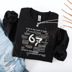 Könnte beinhalten: Schwarzes Sweatshirt mit weißem Text und Grafiken. Der Text enthält "If SIX is the work of man" und "SEVEN is the perfect completion of God". Eine silberne Halskette und blaue Jeans sind ebenfalls im Bild.