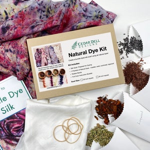 May include: A natural dye kit for silk scarves. The kit includes four packets of natural dyes, rubber bands, a white silk scarf, and instructions. The dyes are labeled: Logwood, Madder Root, Cochineal.