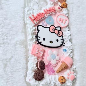 Pu&ograve; includere: Una custodia per telefono rosa e bianca Hello Kitty con un design Hello Kitty 3D, un design a spirale rosa e bianco e vari altri abbellimenti 3D tra cui biscotti, gelato e caramelle.