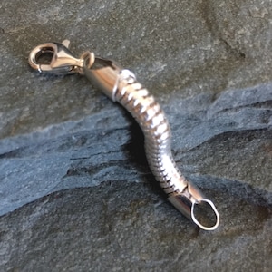 May include: A silver snake chain bracelet with a lobster clasp closure.