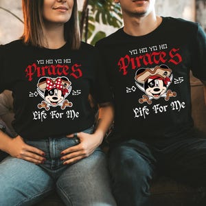May include: Black t-shirts with a pirate-themed design. The shirts feature the text "YO HO YO HO Pirates" in red, along with a cartoon mouse character wearing a pirate hat and holding crossed swords. The text "Life For Me" is below the character.